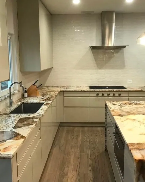Kitchen with a quartzite waterfall island and gloss cabinets